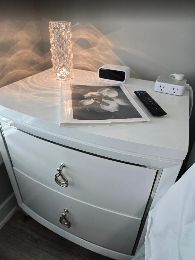 Touch lamp, USB charging, plug box, local guide, TV and ceiling fan remote all within reach.